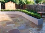patio was constructed useing fossil sandstone in 4 sizes laid to a random pattern with a curved block planter wall painted in gun ship grey and planted with a topiary hedge.