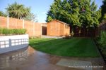 AFTER: New lawn and planting new fence and shed patio was constructed useing fossil sandstone in 4 sizes laid to a random pattern with a curved block planter wall painted in gun ship grey and planted with a topiary hedge.  