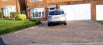Driveway constructed using Marshall's Tegula paving with contrasting colour band and feature curved double row of kerbs with Topiary hedge to retain level change.