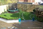 Garden was very unusable with Multiple steps from back doors new deck with inset sandstone sunflower feature was installed with new block rendered planter wall planted with topiary and linking circle lawns edged with granite setts and separate children's 