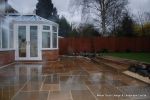 AFTER: Patio installed with 4 size sawn sandstone paving edged with firestone rocks and alpine planting, steps built with sawn sandstone uprights and sawn sandstone bullnose treads 