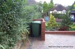 Stepped red brick wall with built in bin cupboard