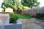 New lawn, planting, shed and fence patio was constructed using fossil sandstone in 4 sizes laid to a random pattern with a curved block planter wall painted in gun ship grey and planted with a topiary hedge.