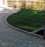 AFTER: Driveway constructed using Tegula paving with sweeping curved path to front door and feature band across drive mouth, new wall, lawn and planting installed.
