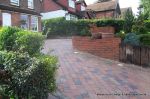 AFTER: Driveway installed with Tegula paving laid at 45 degree to property with in set lighting and feature wall merging into timber wall along front garden and road boundary