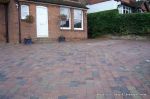 Driveway installed with Tegula paving laid at 45 degree to property with in set lighting and feature wall merging into timber wall along front garden and road boundary