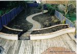 Garden was terraced with decking installed with inset terracotta octagon, curved block rendered wall and sweeping path edged with granite setts  