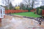 Patio installed with 4 size sawn sandstone paving edged with firestone rocks and alpine planting, steps built with sawn sandstone uprights and sawn sandstone bullnose treads